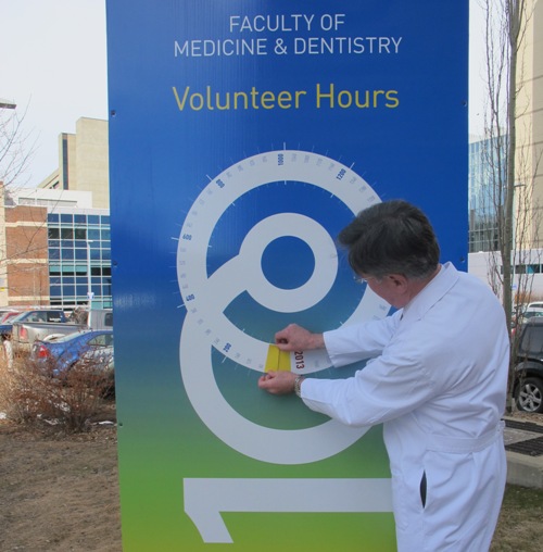 D Douglas Miller, dean of the Faculty of Medicine & Dentistry, adds the first two markers to the Volunteer Challenge meters