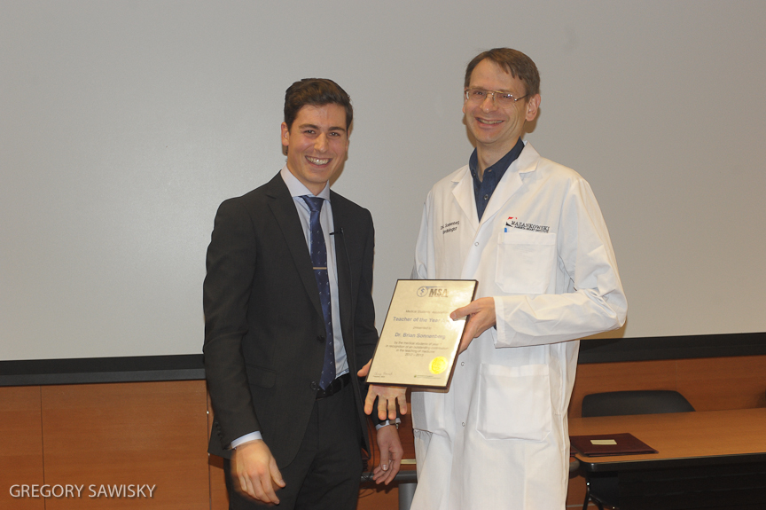 Brian Sonnenberg (r) receives one of his awards from second-year medical student Daniel Skubleny