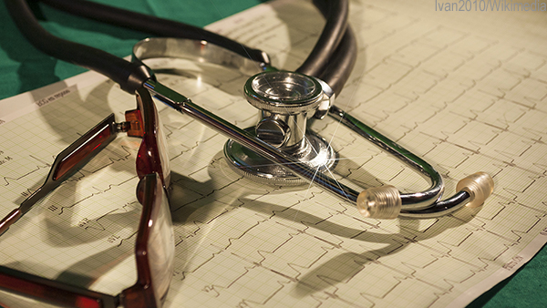 Stethoscope and glasses sit on a cardiology print out. 