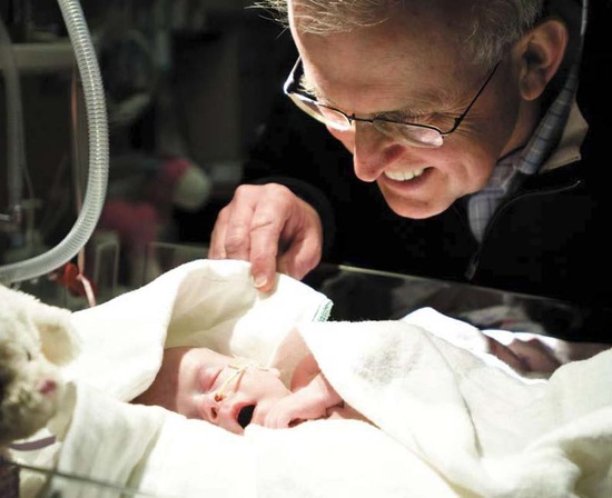 David Olson looks over a newborn baby