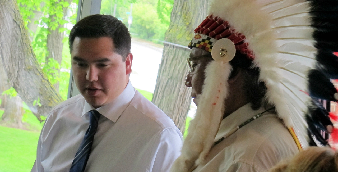 Shey Eagle Bear (left) speaks with Elder Leonard Saddleback during a ceremony recognizing Indigenous medical school graduates in 2014.