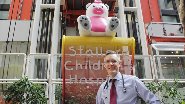 Dr. Andrew Mackie stands in front of the Stollery Children's Hospital sign
