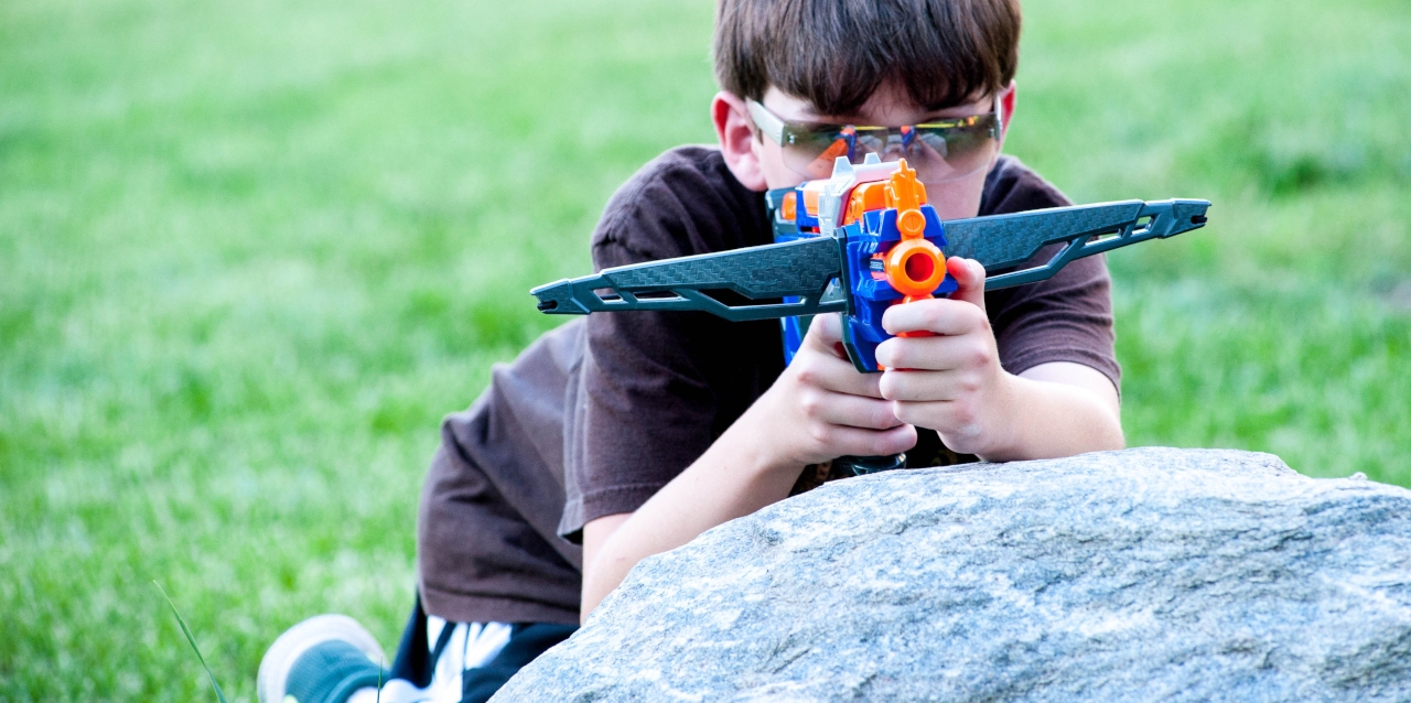 Young boy playing with a Nerf gun.