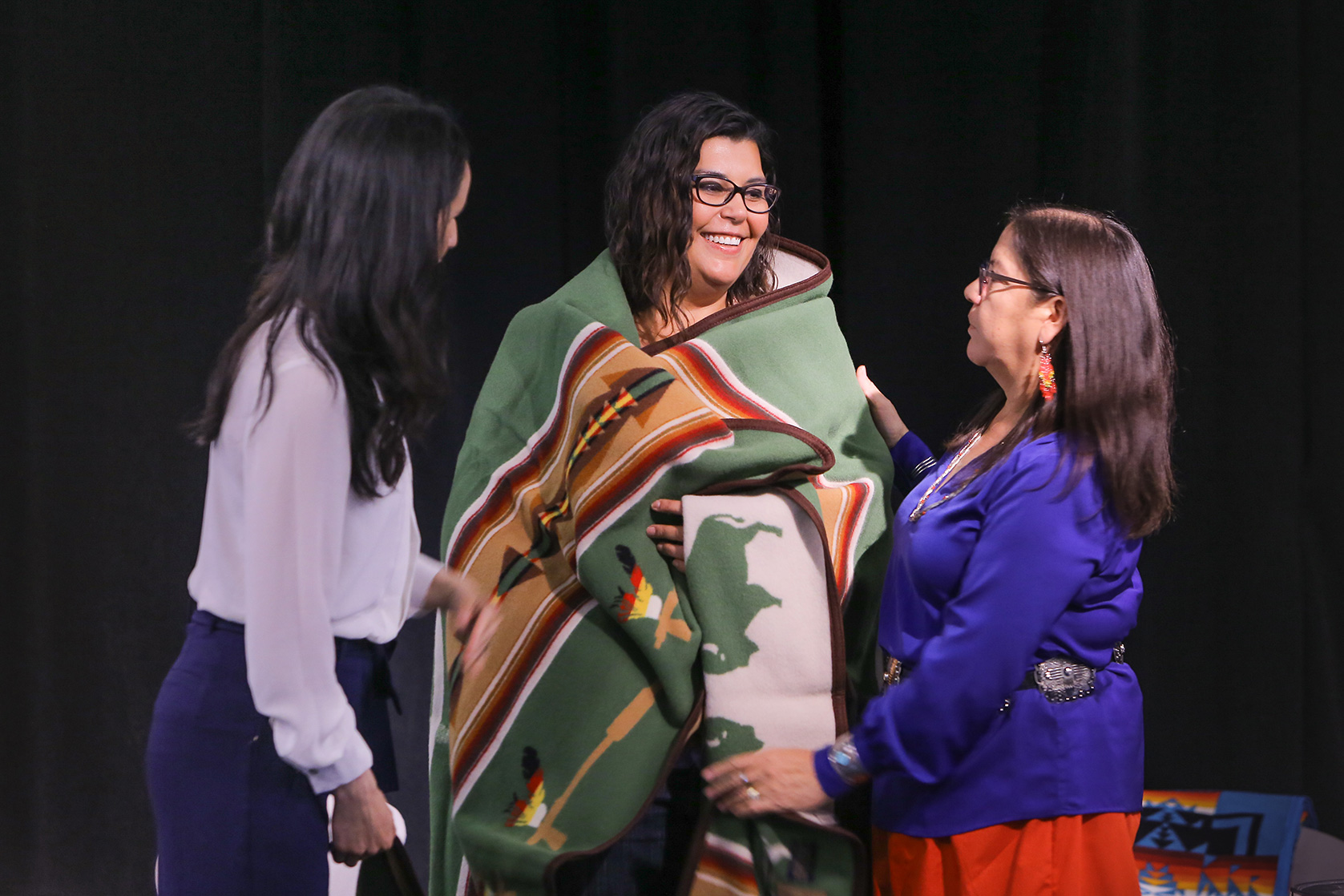 Marcia Anderson (centre) is presented a blanket at the Indigenous Community Gathering.