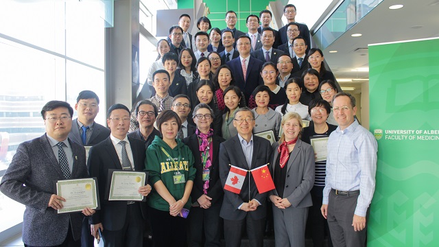 Dr. Dennis Kunimoto and Dr. Mia Lang standing with medical faculty from China
