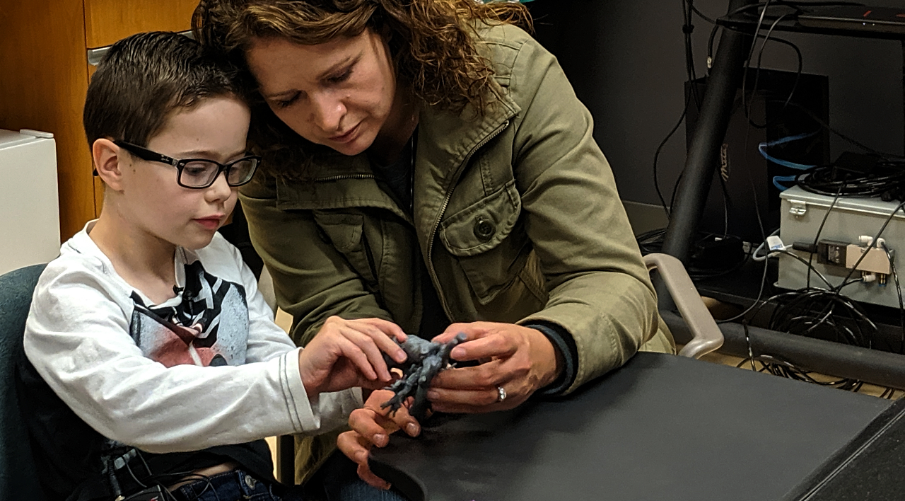 Eight-year-old Mason Thomas and mom Brandie Thomas get their first look at a 3-D printed model of Mason