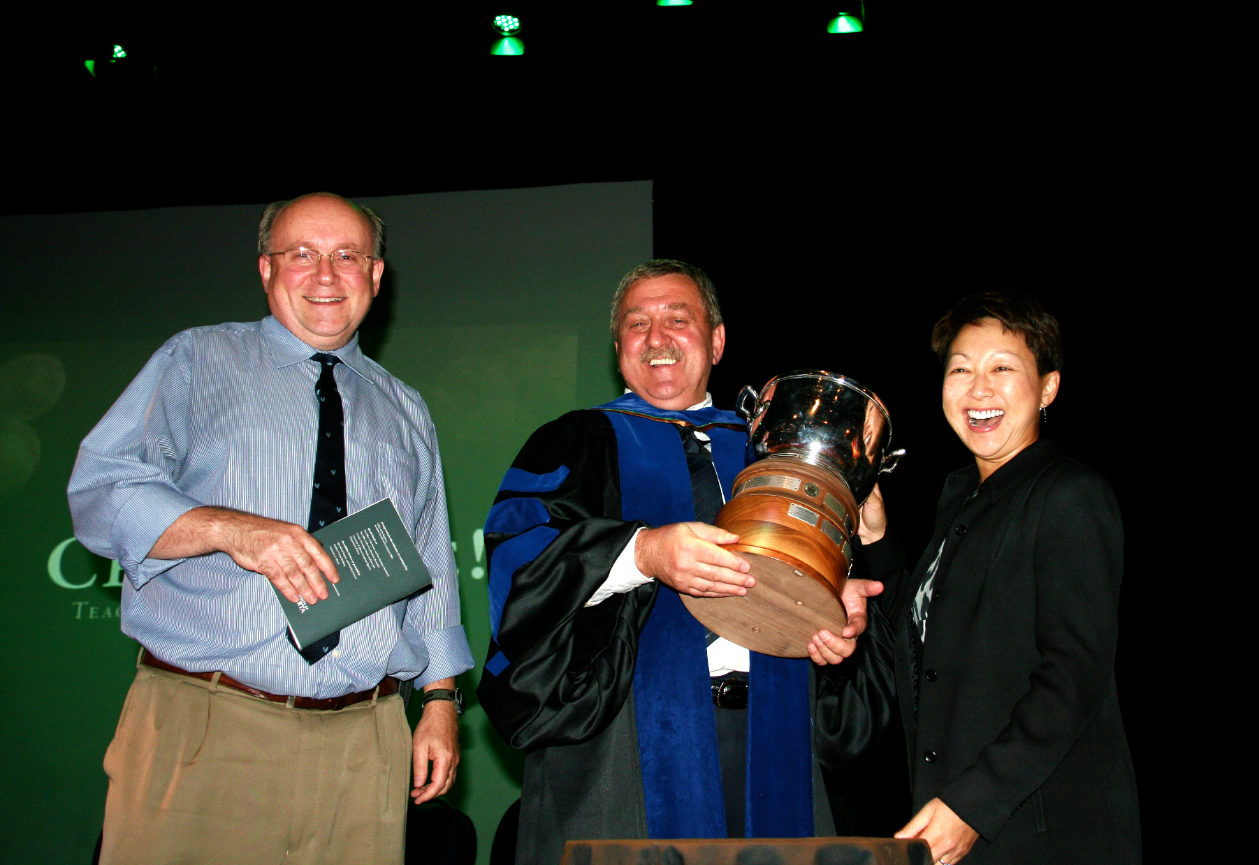 Marek Michalak holding the University Cup next to Charles Holmes and Verna Yiu in 2013