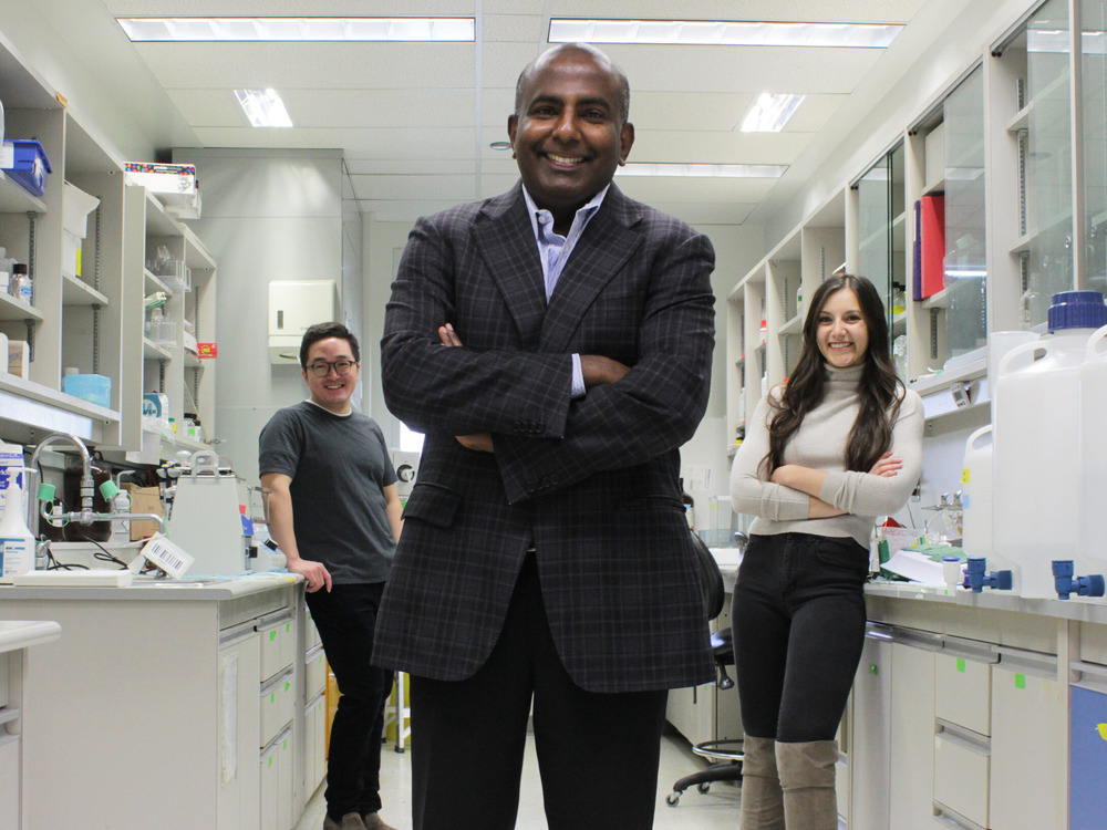 U of A cardiology professor Gavin Oudit stands in the centre of a lab with PhD candidates Hao Zhang and Anissa Viveiros behind him.