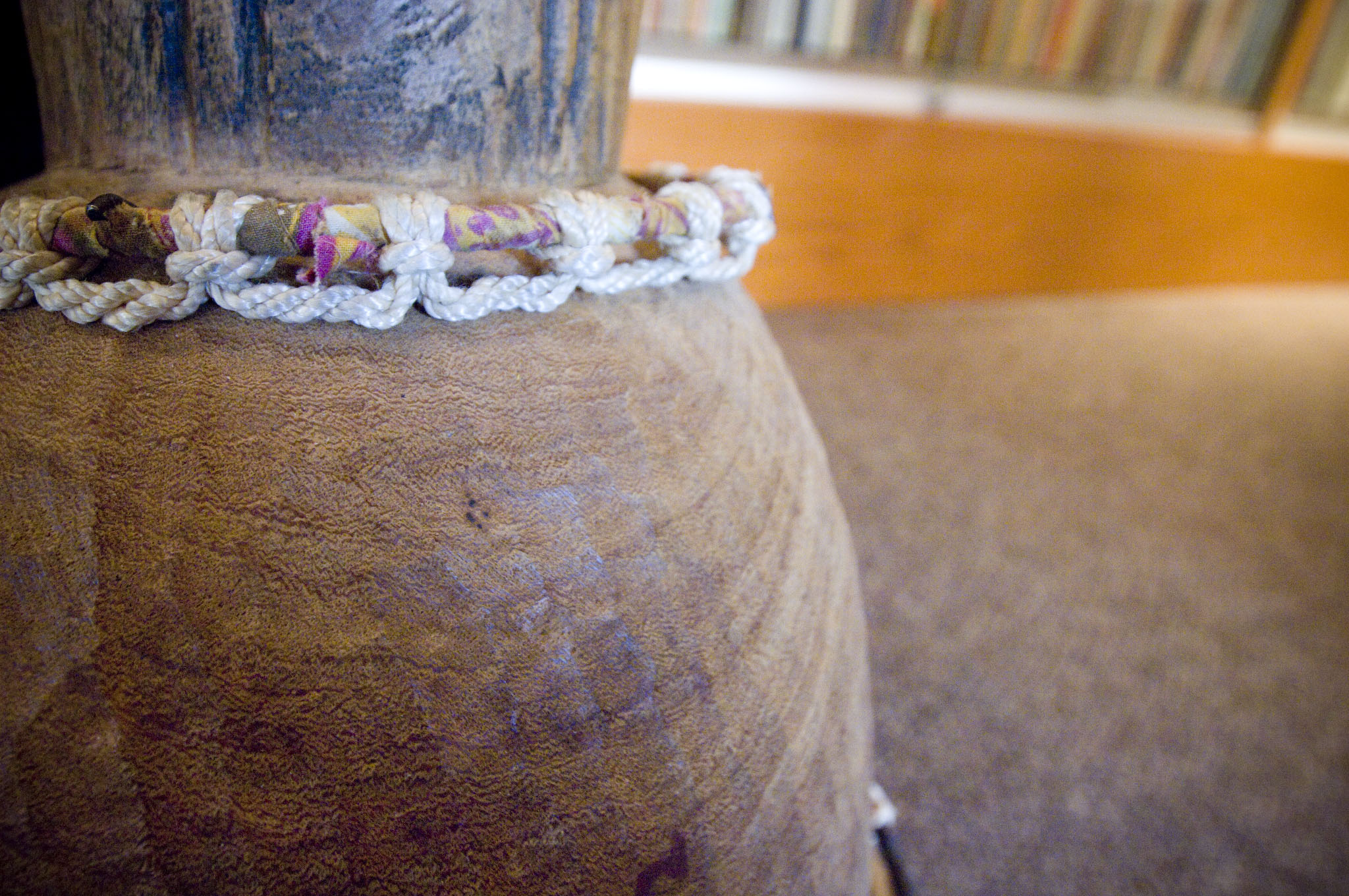 The base of a large drum with a white macramed collar fitted around the neck as it transitions to a wide base