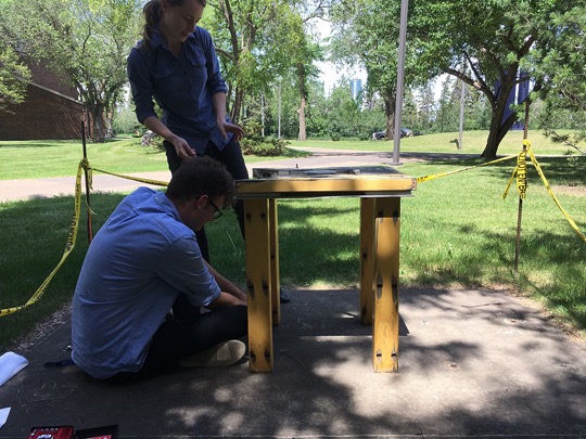 Removing a table-like piece of public art outdoors.