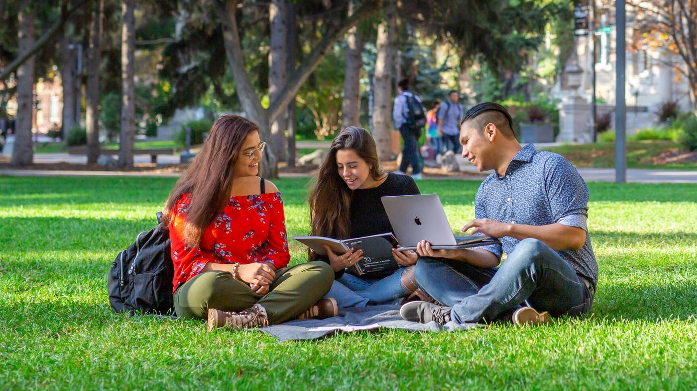 Three students studying on North Campus in front of the Old Arts building