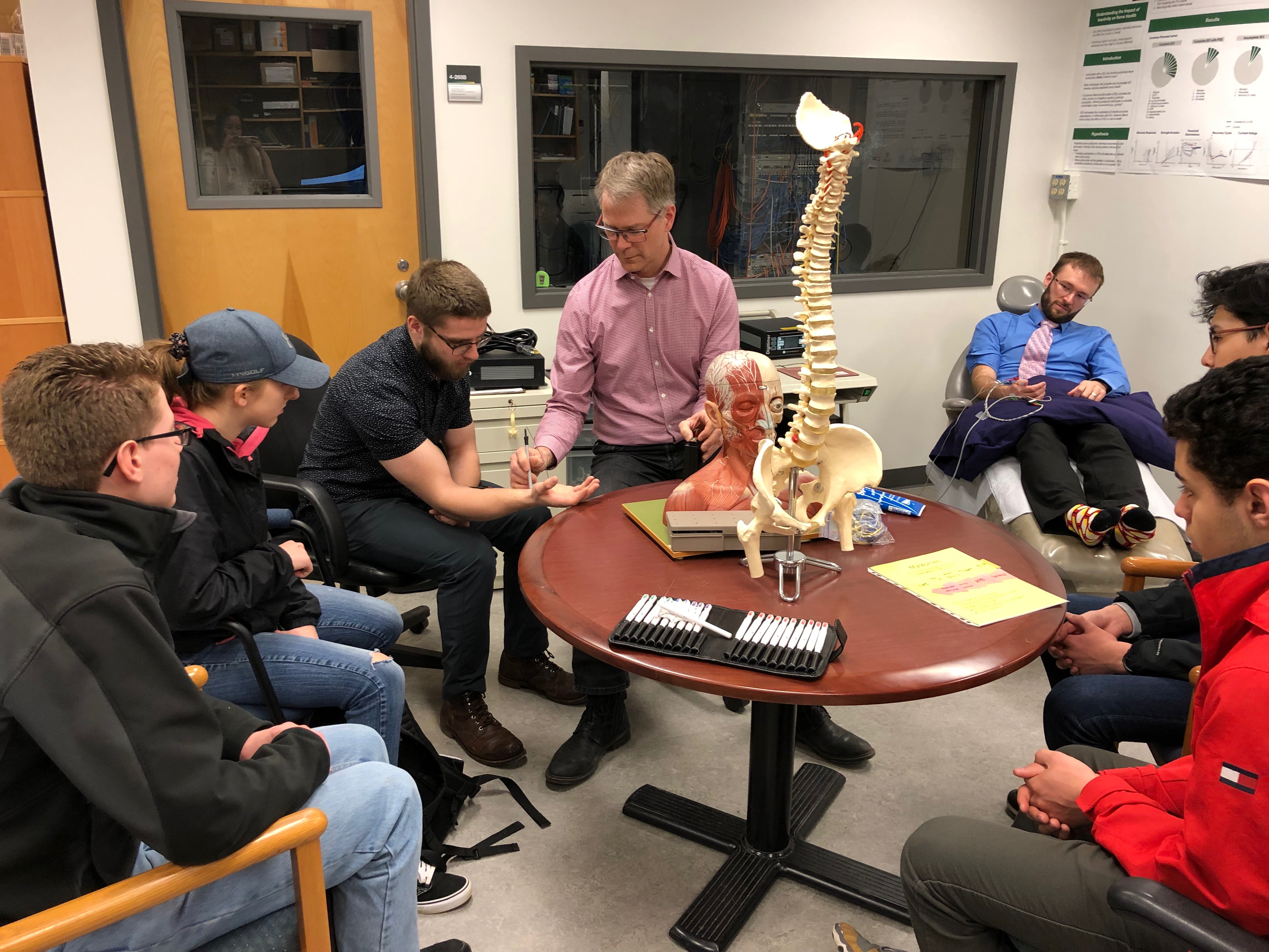 People in a small room discussing a spine