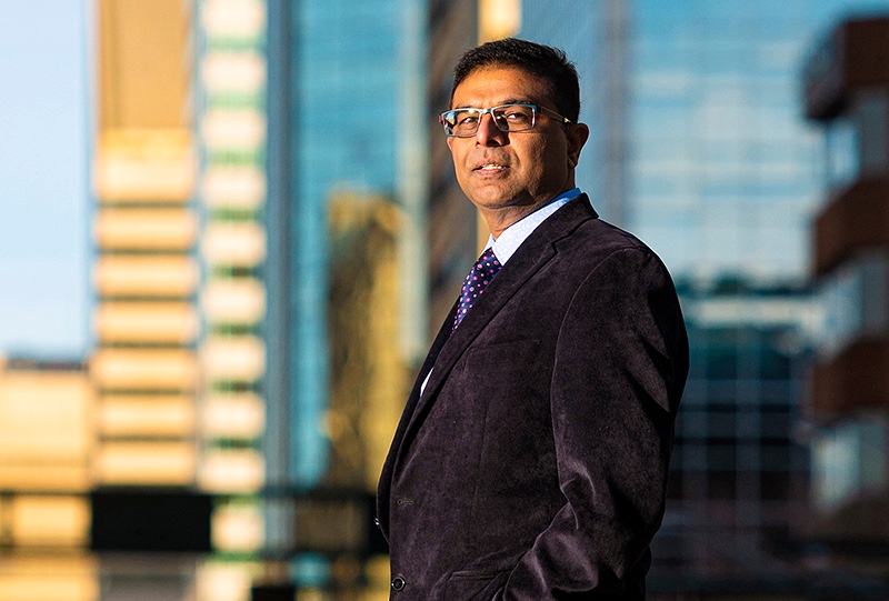 Sandeep Agrawal looking beyond the camera with blurred cityscape in the background