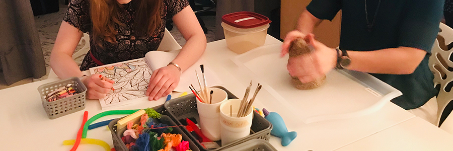one person colouring and another molding clay