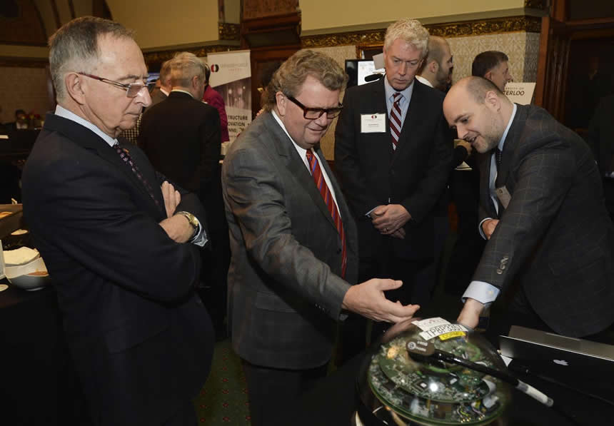 Hon. Kelvin Kenneth Ogilvie (Senator, chair of the Senate committee for Social Affairs, Science and Technology), Hon. Ed Holder (Minister of State - Science and Technology) and Mark Dietrich (President and CEO Compute Canada-Calcul Canada) learn about an IceCube detector module from University of Alberta Associate Professor Darren Grant. Photo supplied by Compute Canada/Calcul Canada.