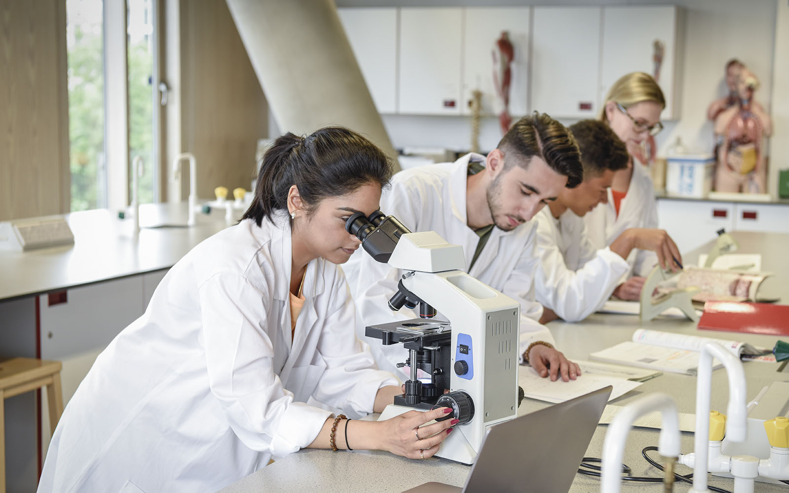 People in lab coats at a lab bench