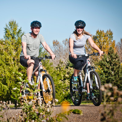 Adult couple riding bicycles in the river valley of Edmonton.