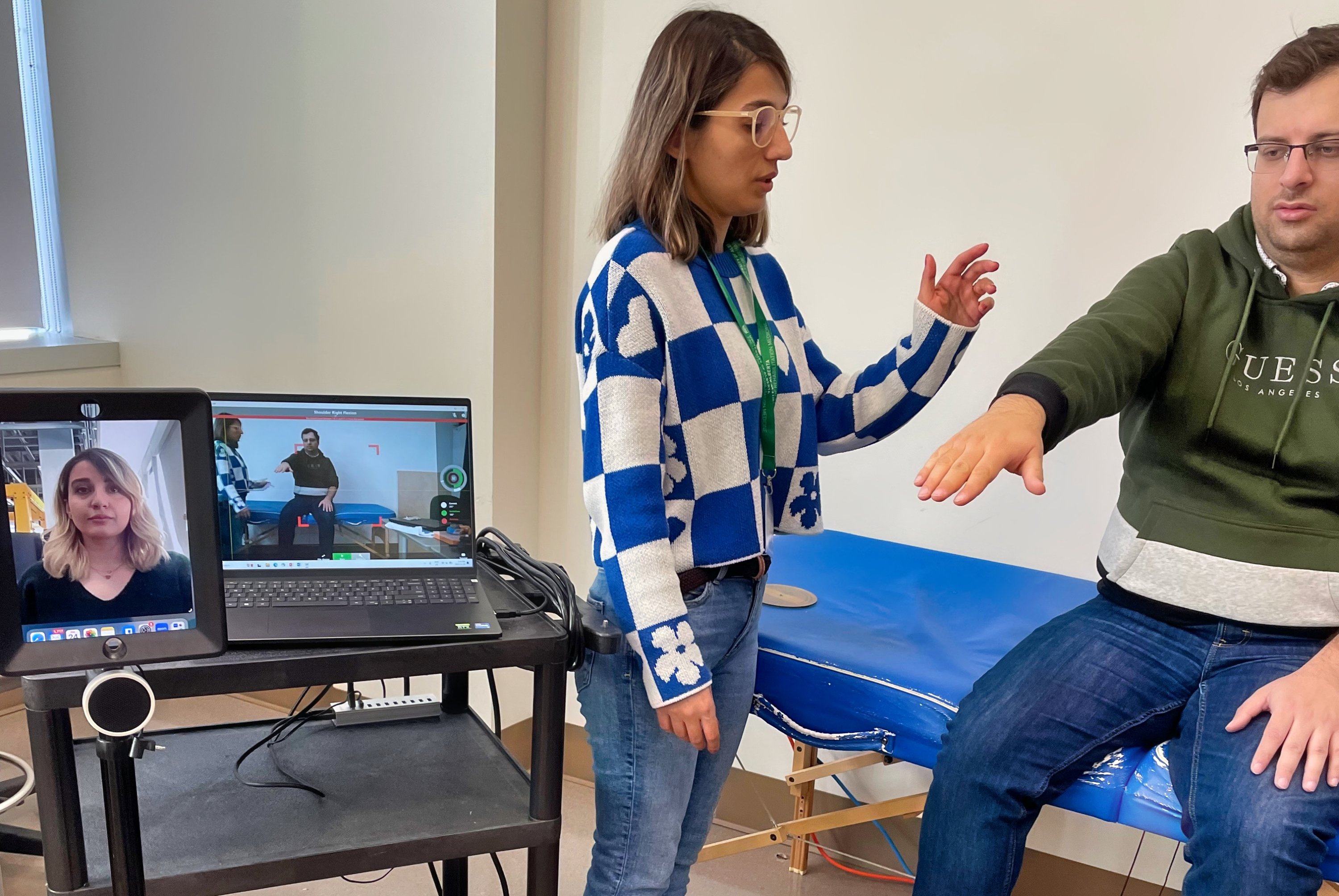 Students Mahtab (standing) and Javad (seated) practise a telerehabilitation procedure using markerless motion capture to measure a patient’s shoulder range of motion. (Photo: Supplied)