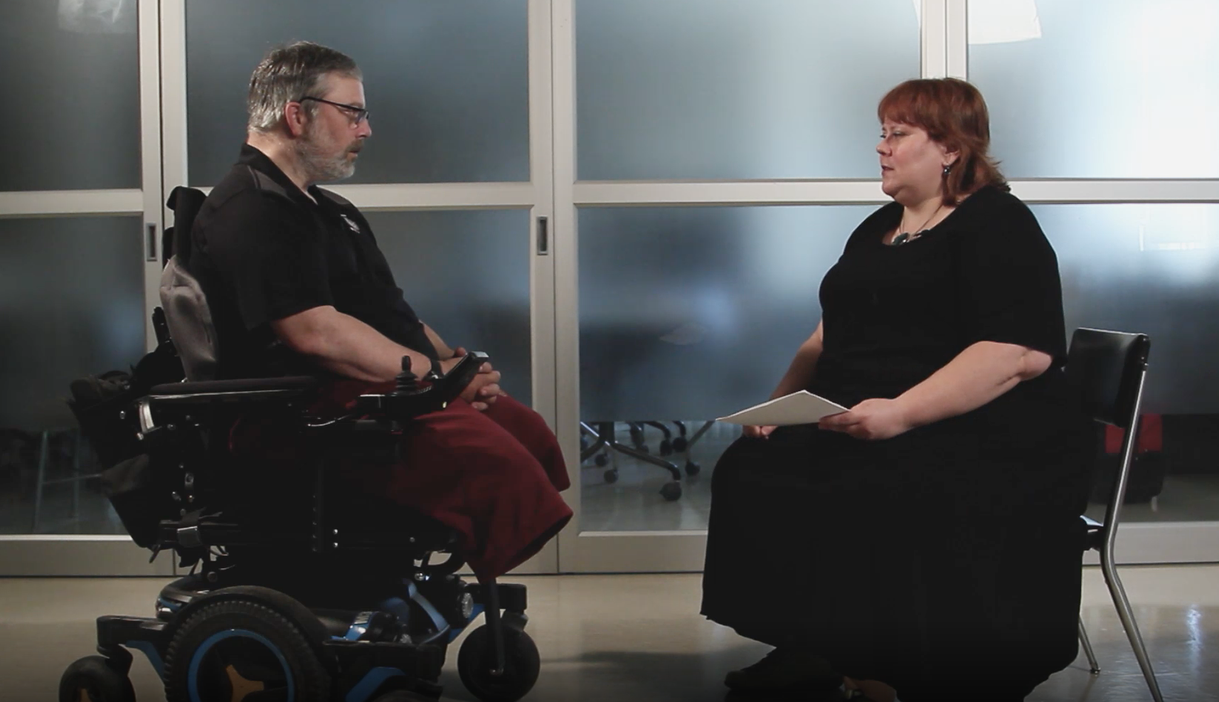 individual in wheelchair being interviewed by wheelchair fitting specialist