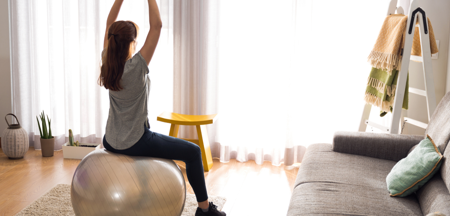 woman on exercise ball in apartment