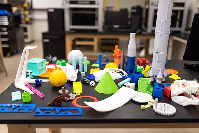 An assortment of models created using computer assisted design and printed out. 3D printing allows students to bring prototype ideas into a physical form without a heavy cost to fabricate each iteration for possible improvement. Such examples include models, tools, instruments, and measuring devices