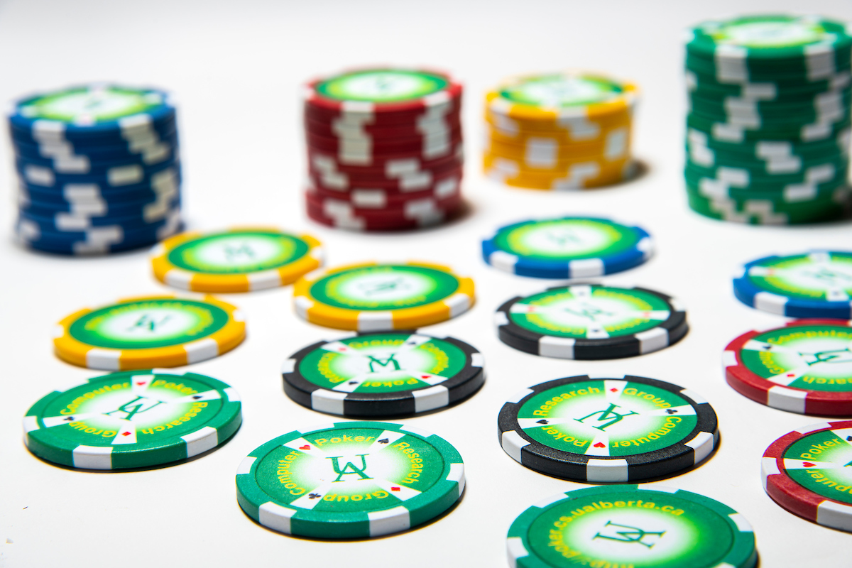Stacks of red, green, yellow, blue, and black poker chips on a white background.