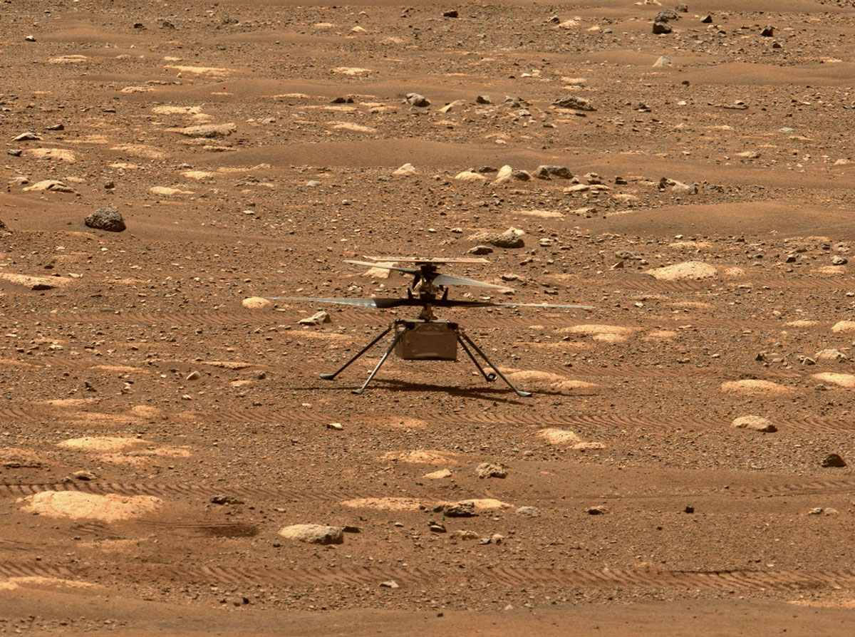 NASA’s Ingenuity helicopter with its rotor blades unlocked, allowing them to spin freely for the first time since launch. The blades were locked into place during its trip, but here, the helicopter readies to attempt the first powered, controlled flight on another planet, as the Perseverance rover captures images.