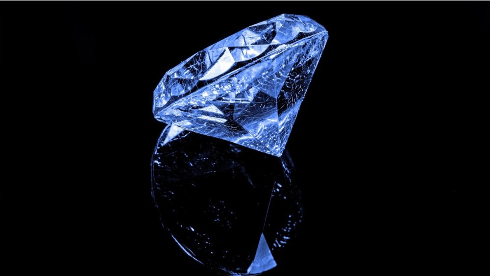 a single blue diamond on a reflective black surface