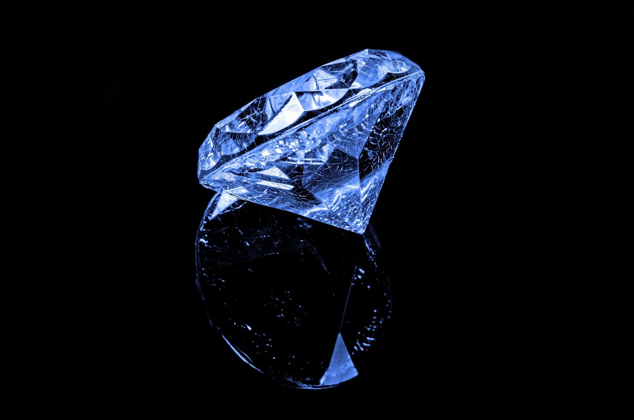 a single blue diamond on a reflective black surface