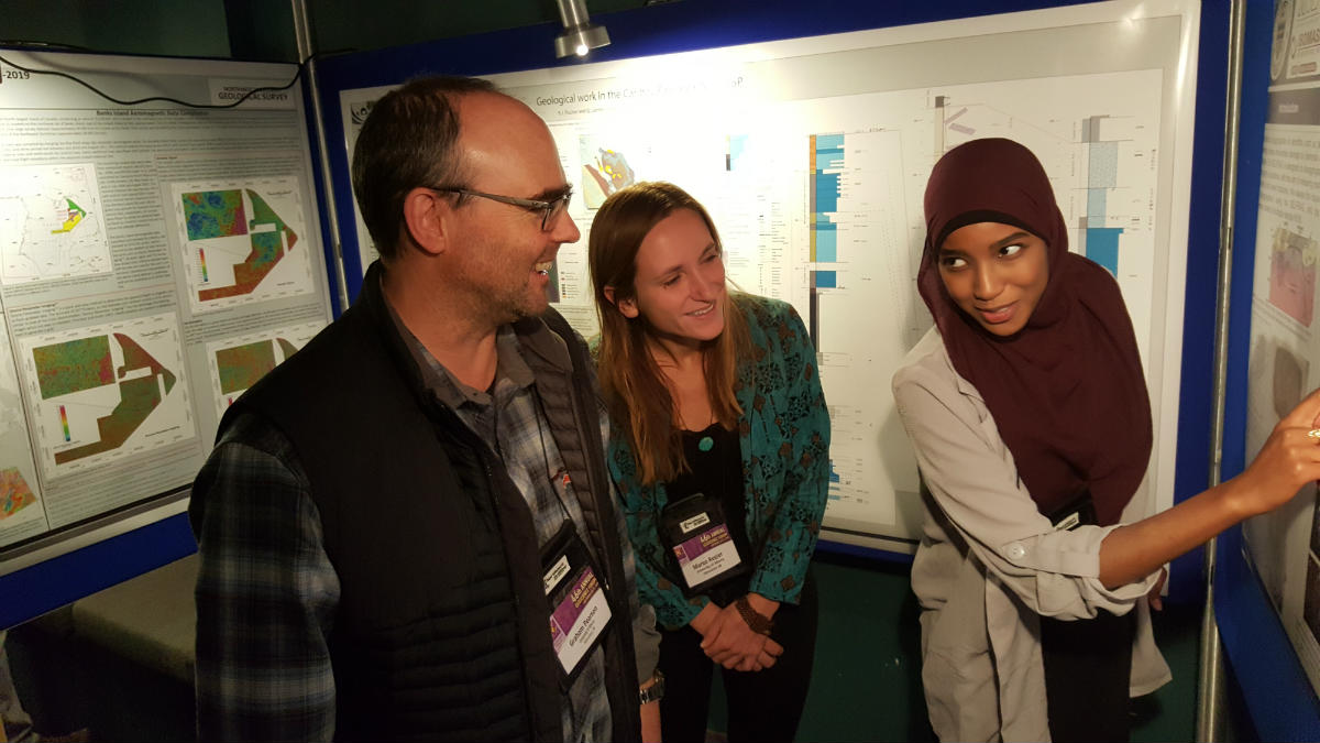 Hamdi Ali presents at the Yukon Geoscience Forum, accompanied by Graham Pearson and Margo Regier.