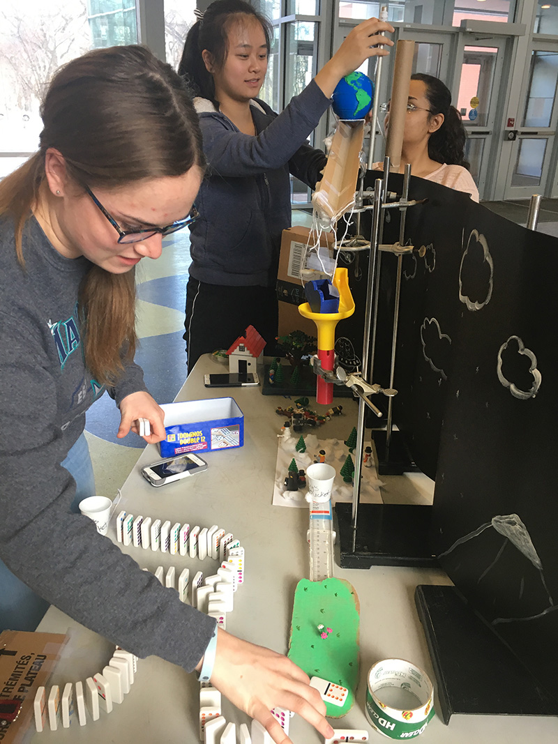 InSciTE students Hayley Karst, Kai Jun Ma, and Tanushka Anand (L to R) work on their section of the Rube Goldberg machine