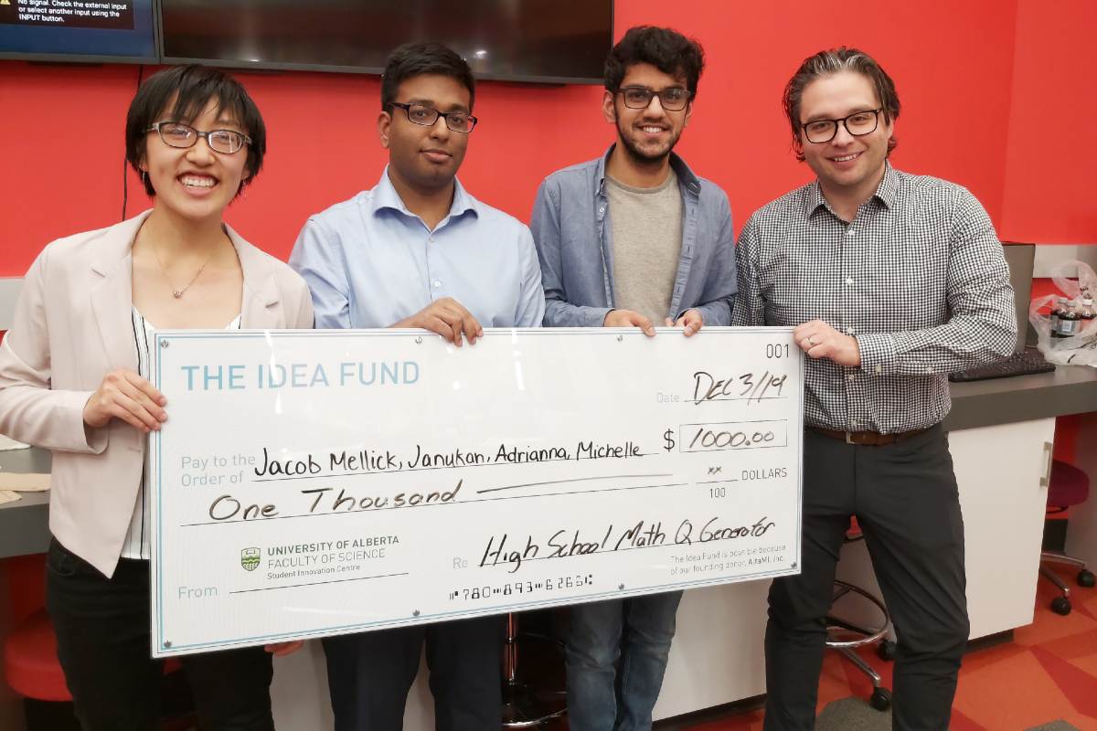 Students from a winning team behind a high school math study application are presented with their prize by Chad Langager, panel judge and vice-president (product) at AltaML-whose support of the Idea Fund made the event possible.