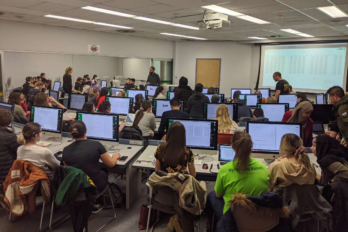 Students in a classroom on campus in Fall 2019, using EEG headsets in the lab.