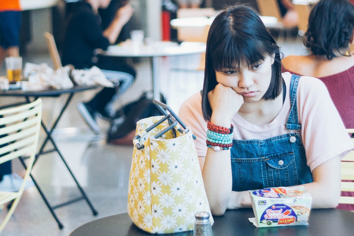A student sits alone at a table. In this issue of Dear Maddi, psychologist and guest author Jasmine Nathoo shares tips on how to be less scared of other people’s opinions.