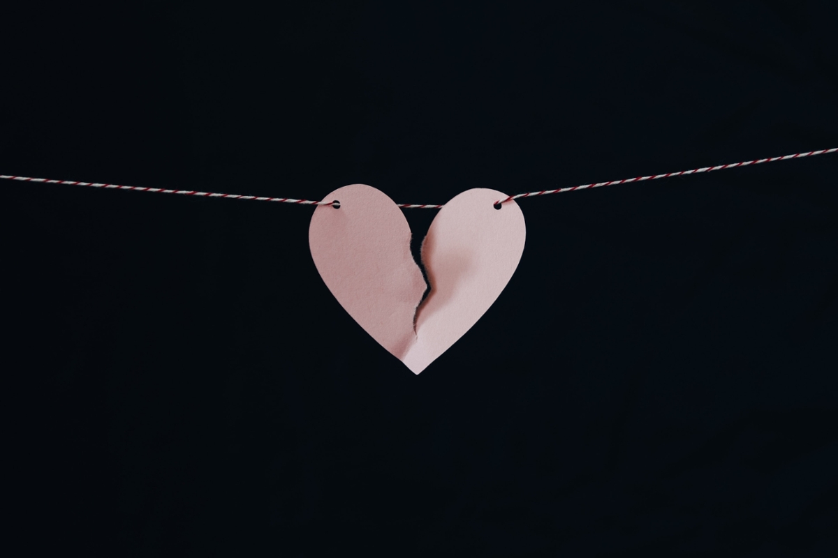 A broken paper heart hangs on a string. Photo credit: Kelly Sikkema on Unsplash