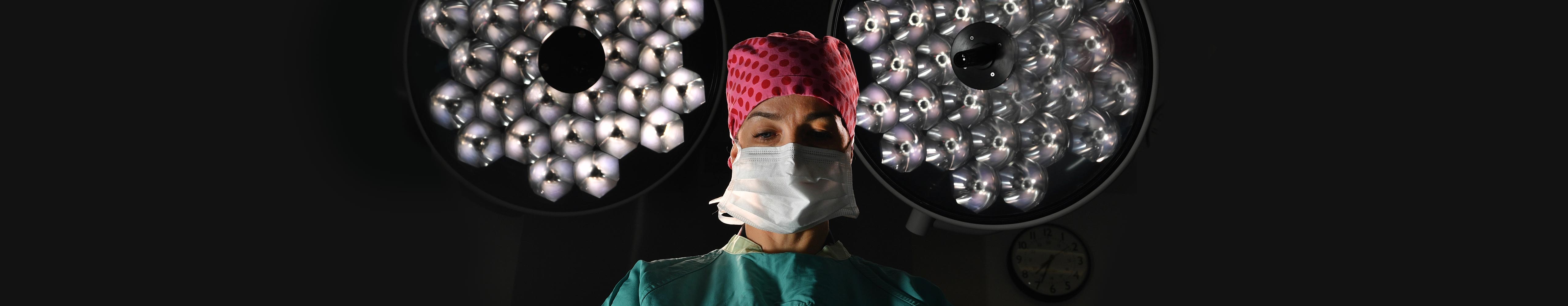 Surgeon conducting surgery with lights behind