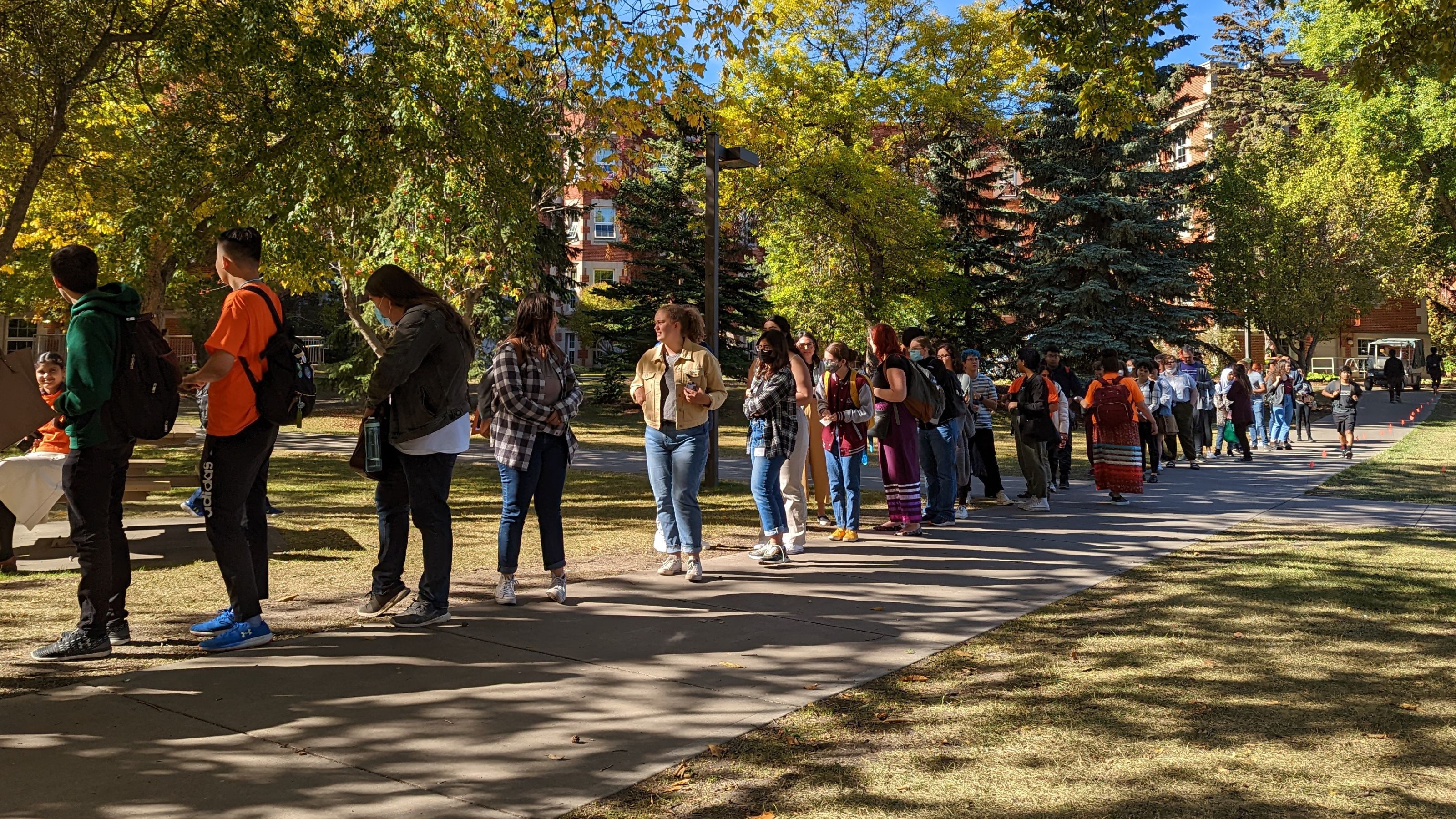 Participants line up to place flags as part of the Residential School Memorial in Main Quad of North Campus.
