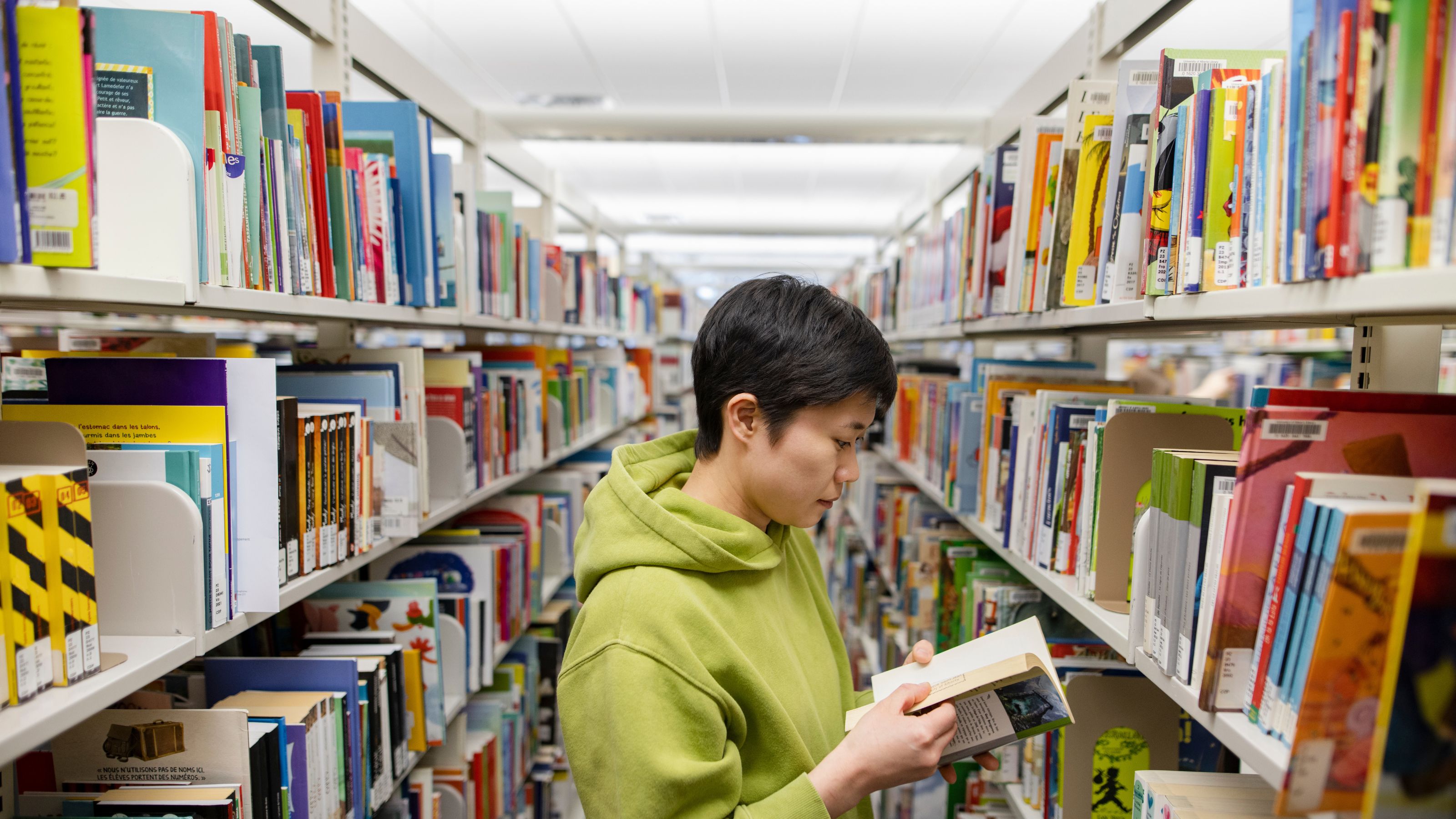 Student in library accessing free textbooks.